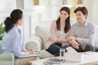 Counselor and happy couple after effective marital therapy