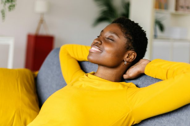 Young African American woman relaxing on a sofa at home.